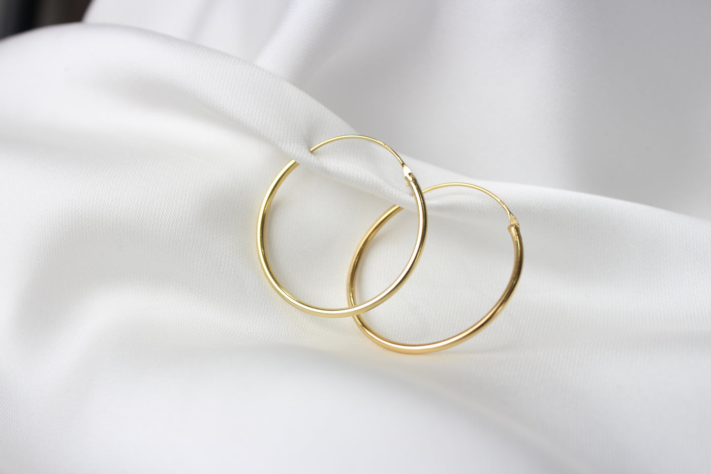 A pair of classic 30mm gold-plated hoop earrings with a smooth, minimalist design, sterling silver gold plated